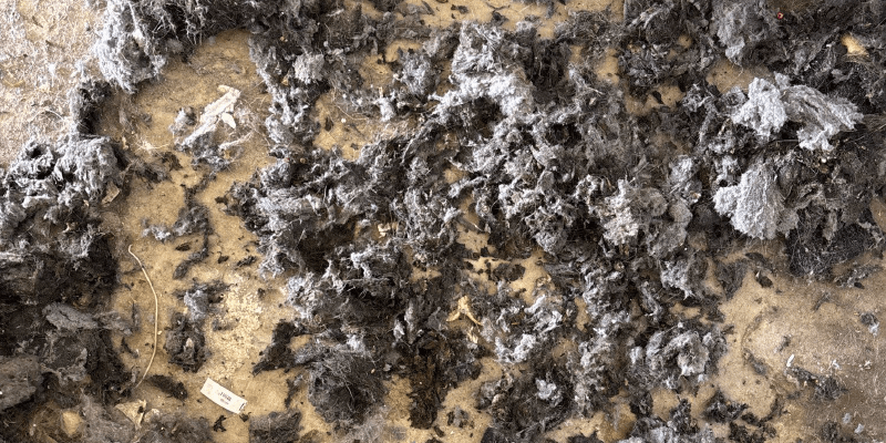 a close-up of Air Duct Cleaners Zr Wand cleaning dirt on a light gray textured air duct to help eliminate dust mites from hot water extraction methods